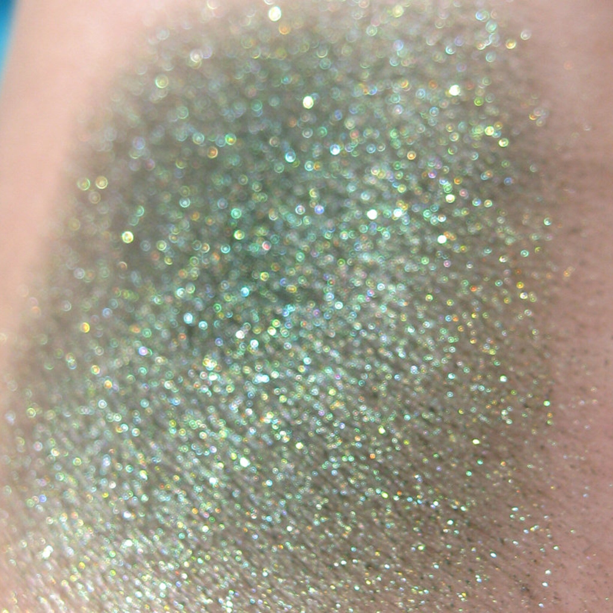 Side view of Vegan Halloween Snake Charmer Eye Shadow palette showing emerald green and black shimmery shades