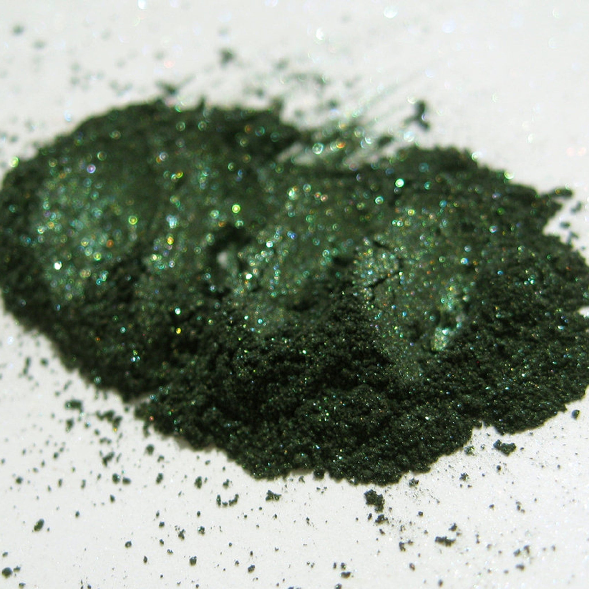 Close-up of Vegan Halloween Snake Charmer Eye Shadow pan showing emerald green shimmer with intricate snake-scale pattern.