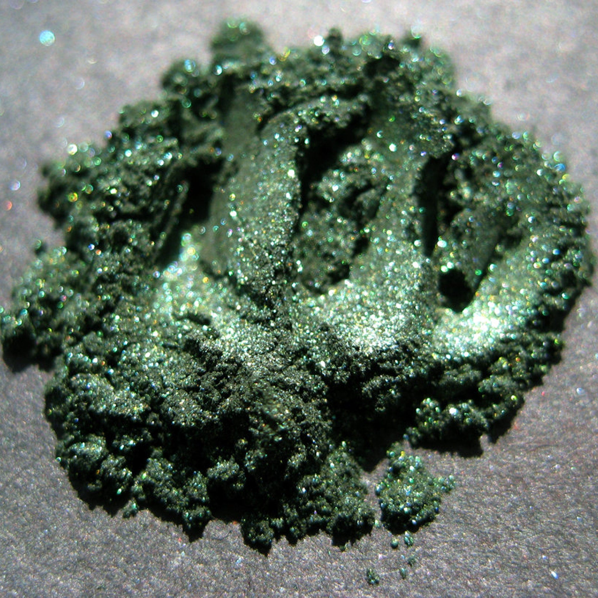Side view of Vegan Halloween Snake Charmer Eye Shadow palette showing shimmering green and black shades in rectangular pans