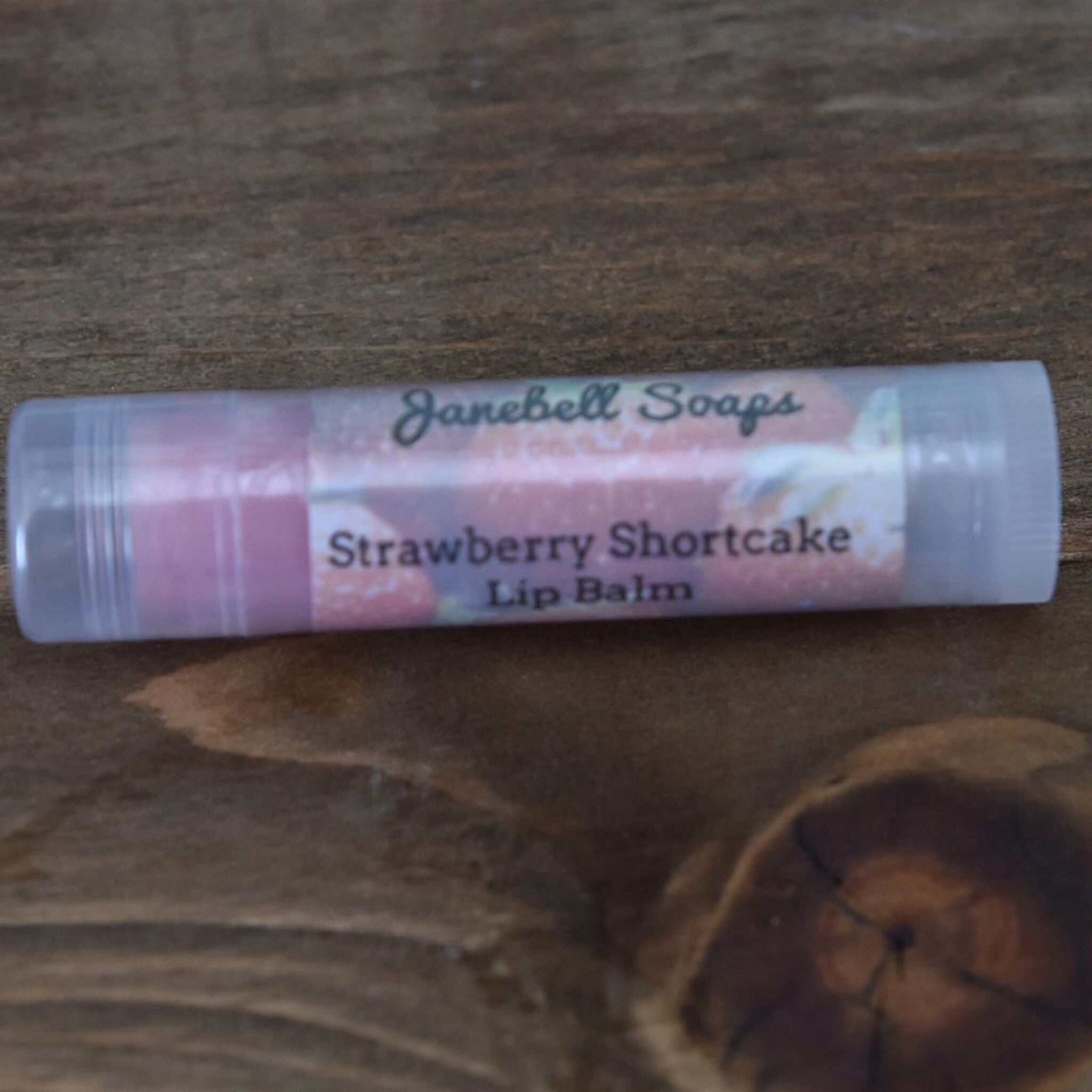 Lip balm tube with pink and white label, clear plastic container, by Janebell Soaps