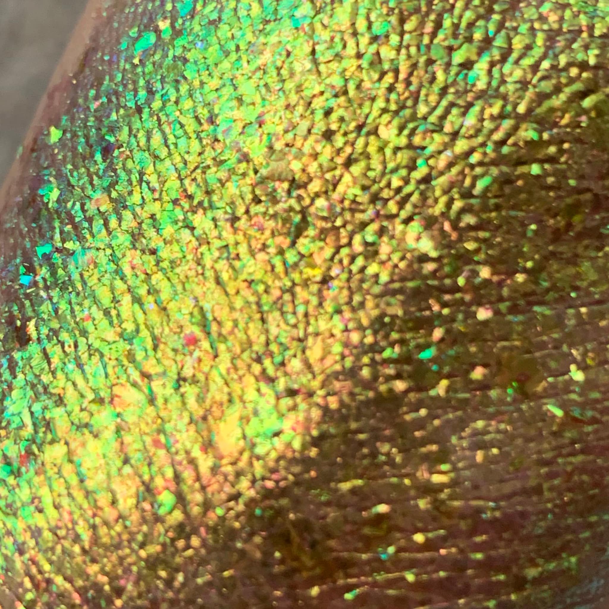 Glitter eyeshadow with yellow, green, and iridescent shimmer on skin