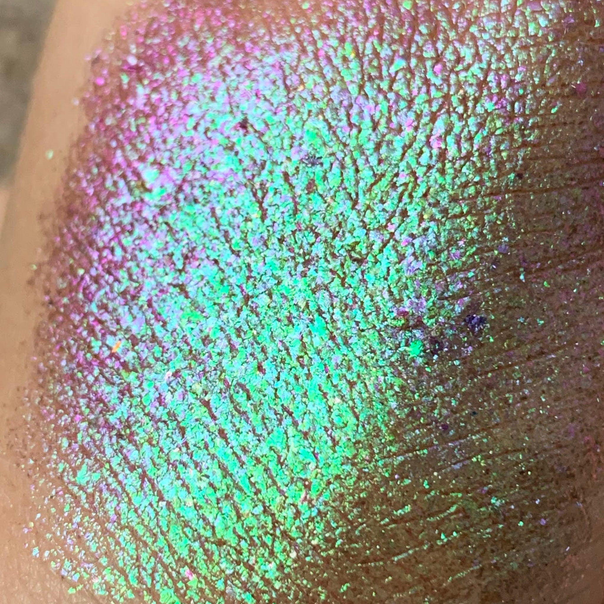 Side view of Tala Foil Candy Eye Shadow Pigment in shade FL13 showing metallic pink shimmer in angled light