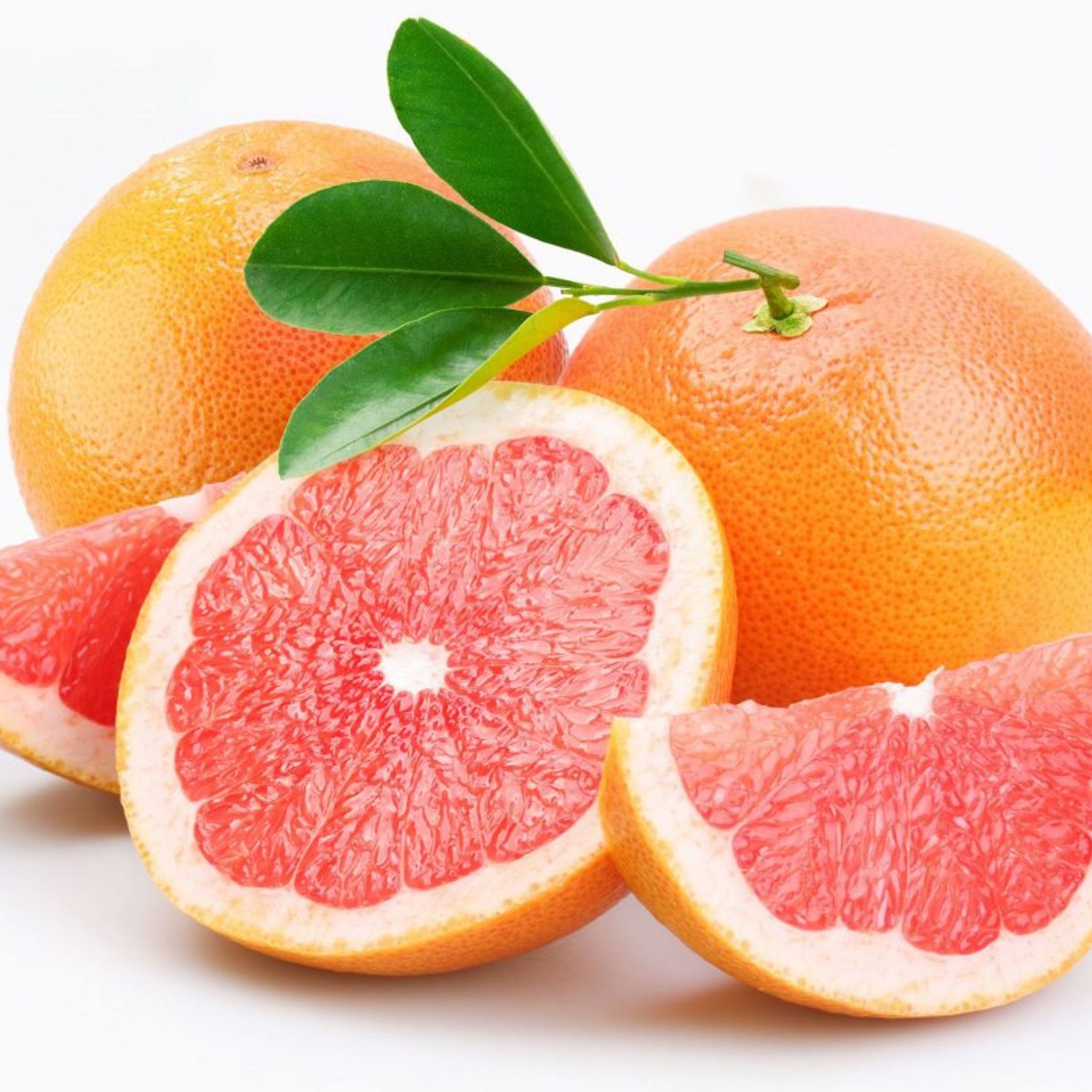 Grapefruit with orange skin and red flesh, with green leaves, cut and whole