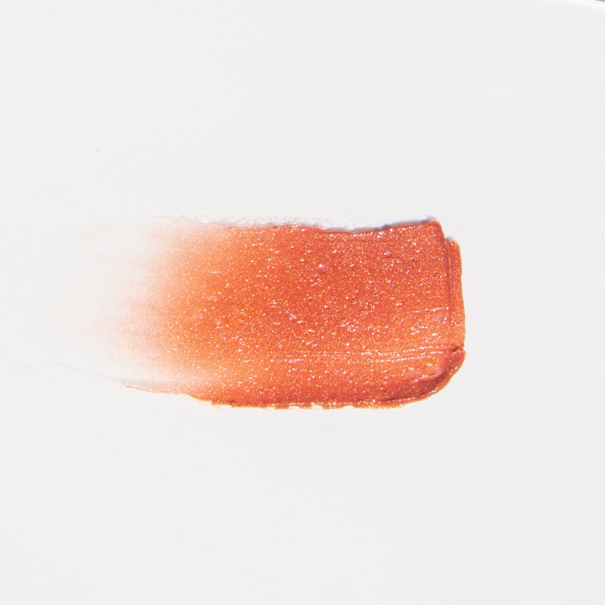 Lip gloss swatch, orange-red shimmer, glossy texture, on white background