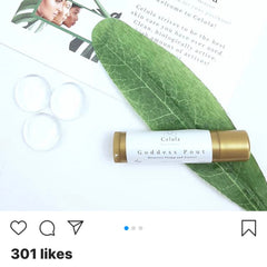 Lip balm with gold tube and white label, green leaf, and clear spheres, Celula brand