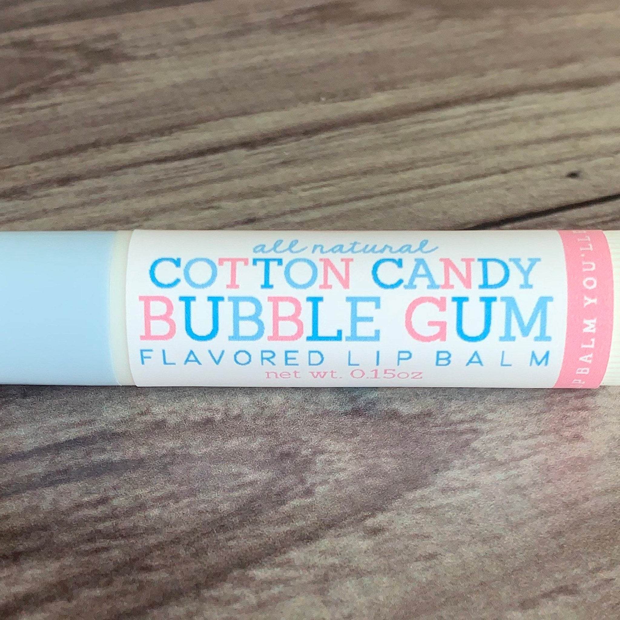 Lip balm tube with blue and white, pink text, and Cotton Candy Bubble Gum flavor