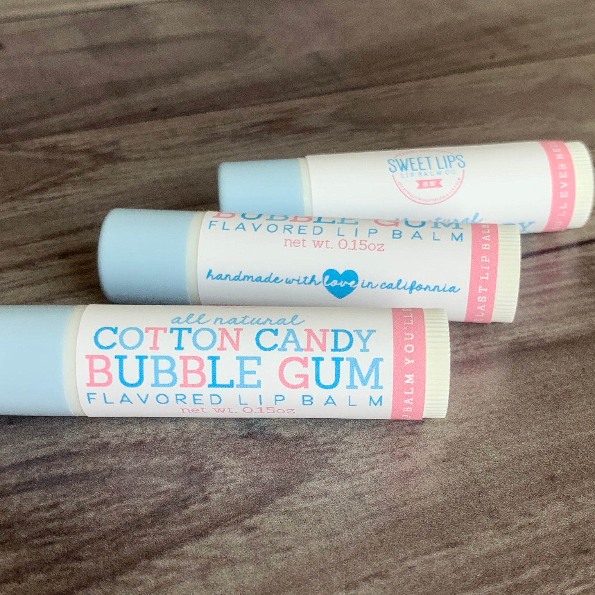 Lip balm tubes with blue and white packaging, pink and blue text, and Sweet Lips branding.