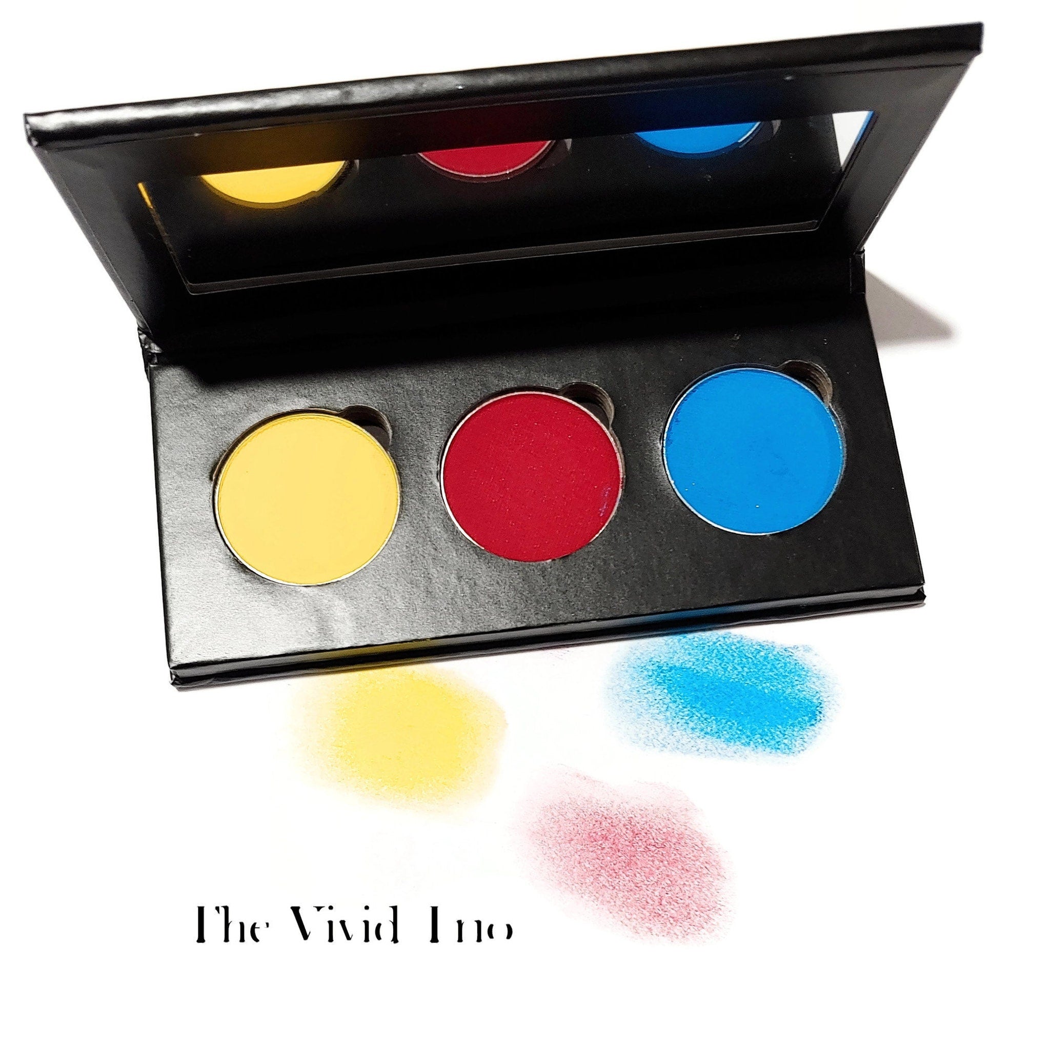 Eye shadow palette with yellow, red, and blue colors in black compact, The Vivid Trio text visible