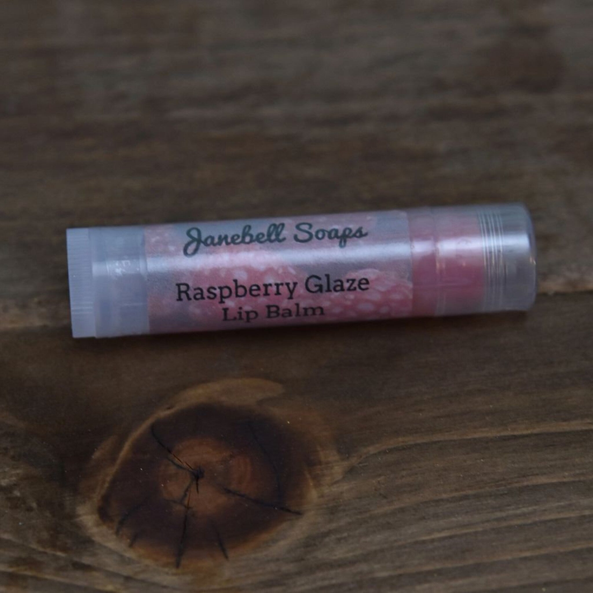 Lip balm tube with clear plastic, pink balm, and Janebell Soaps text on label