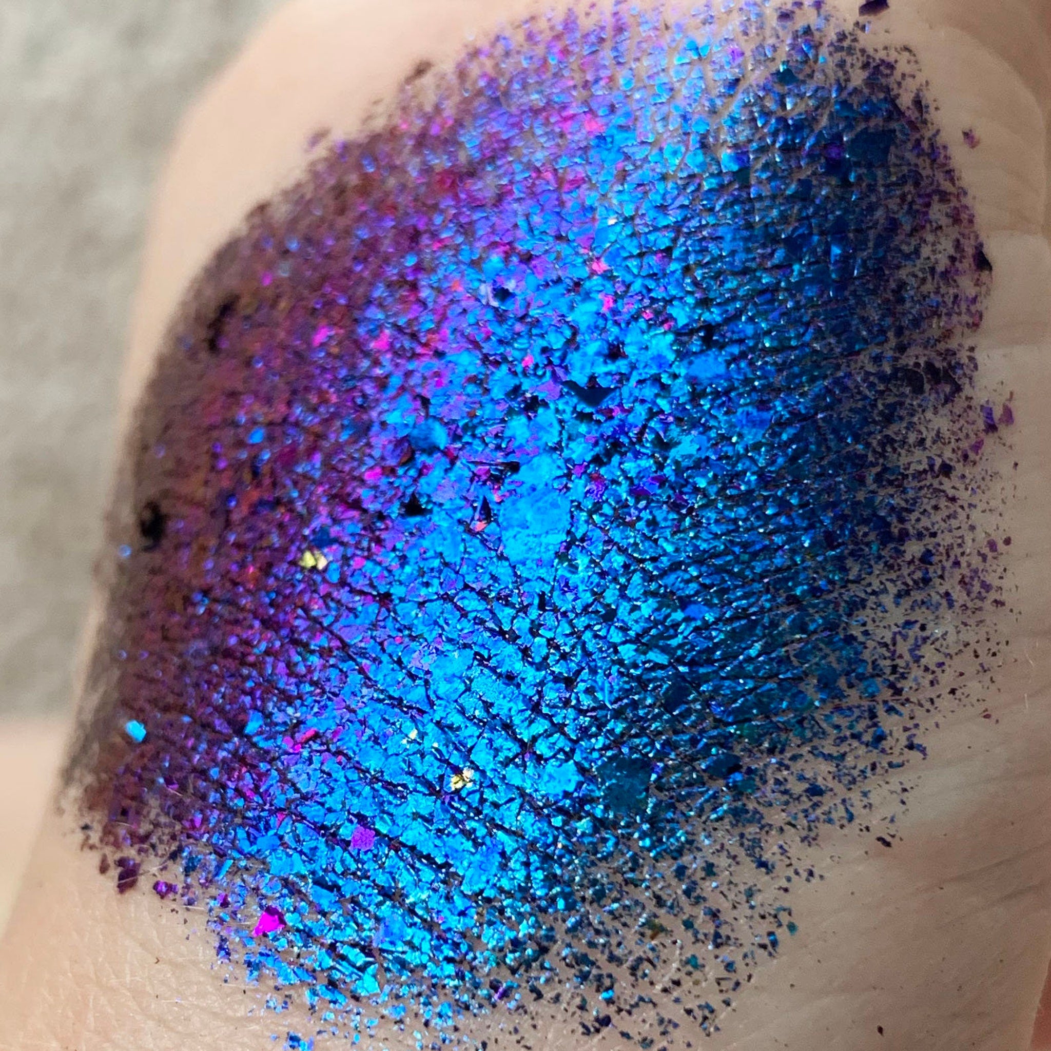 Close-up of Tala Foil Thunderstorm Eye Shadow Pigment in metallic silver-blue with shimmer particles, showing texture detail.