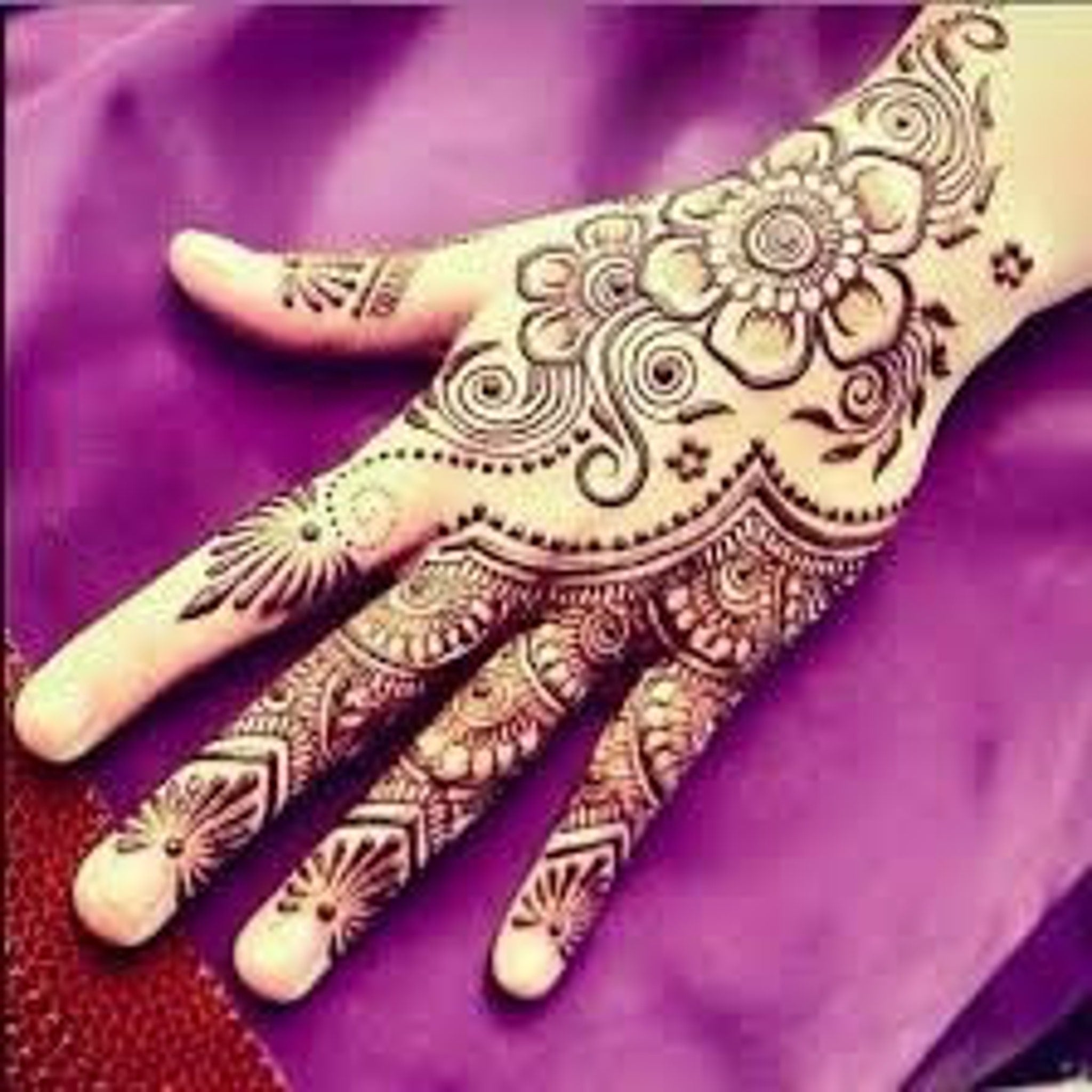 Close-up of natural brown henna cone tip with smooth texture, ready for precise skin application.