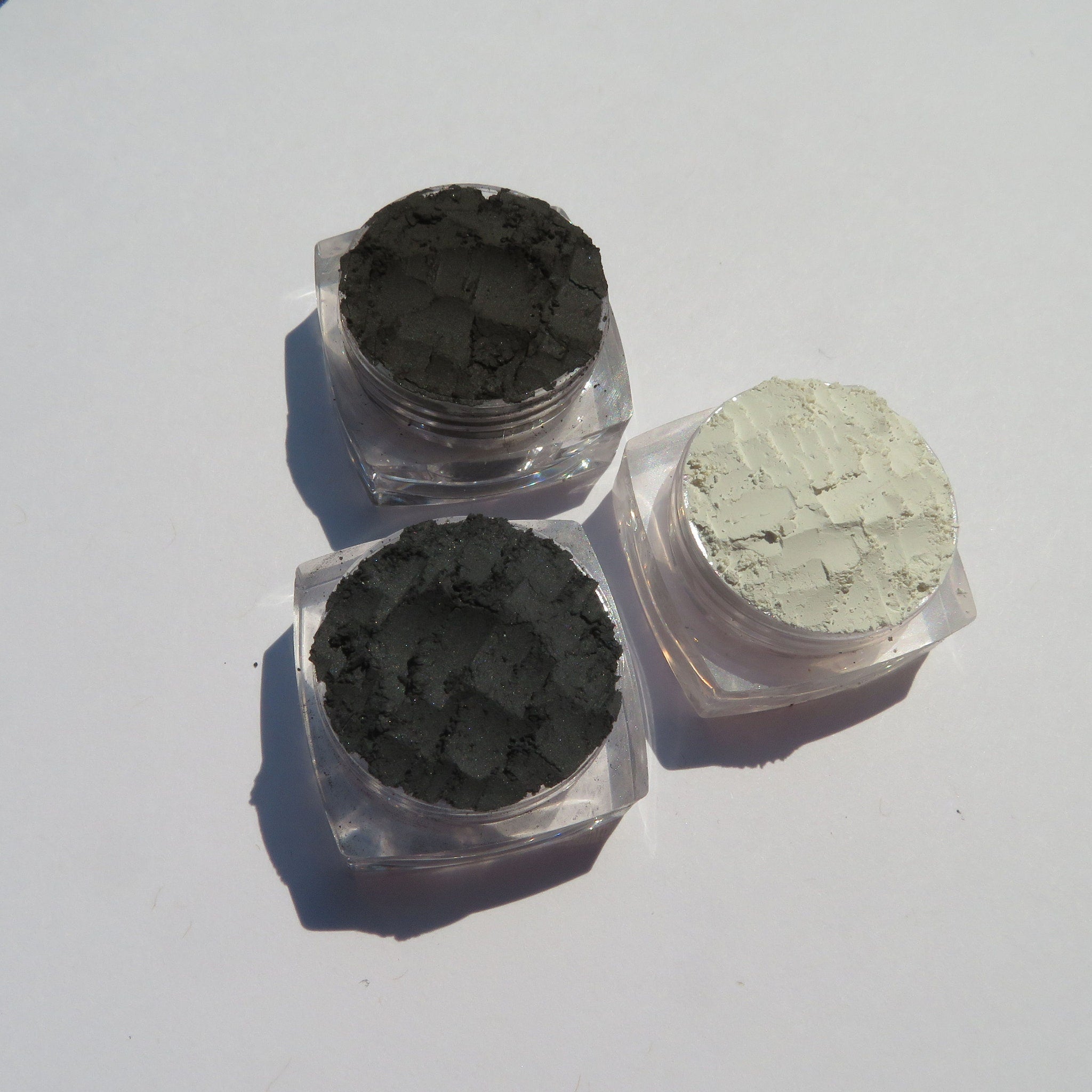 Close-up of matte dark brown eyeshadow pan with smooth texture and vegan label visible