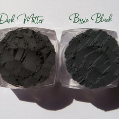 Hand applying matte black vegan eyeshadow with a blending brush onto eyelid crease