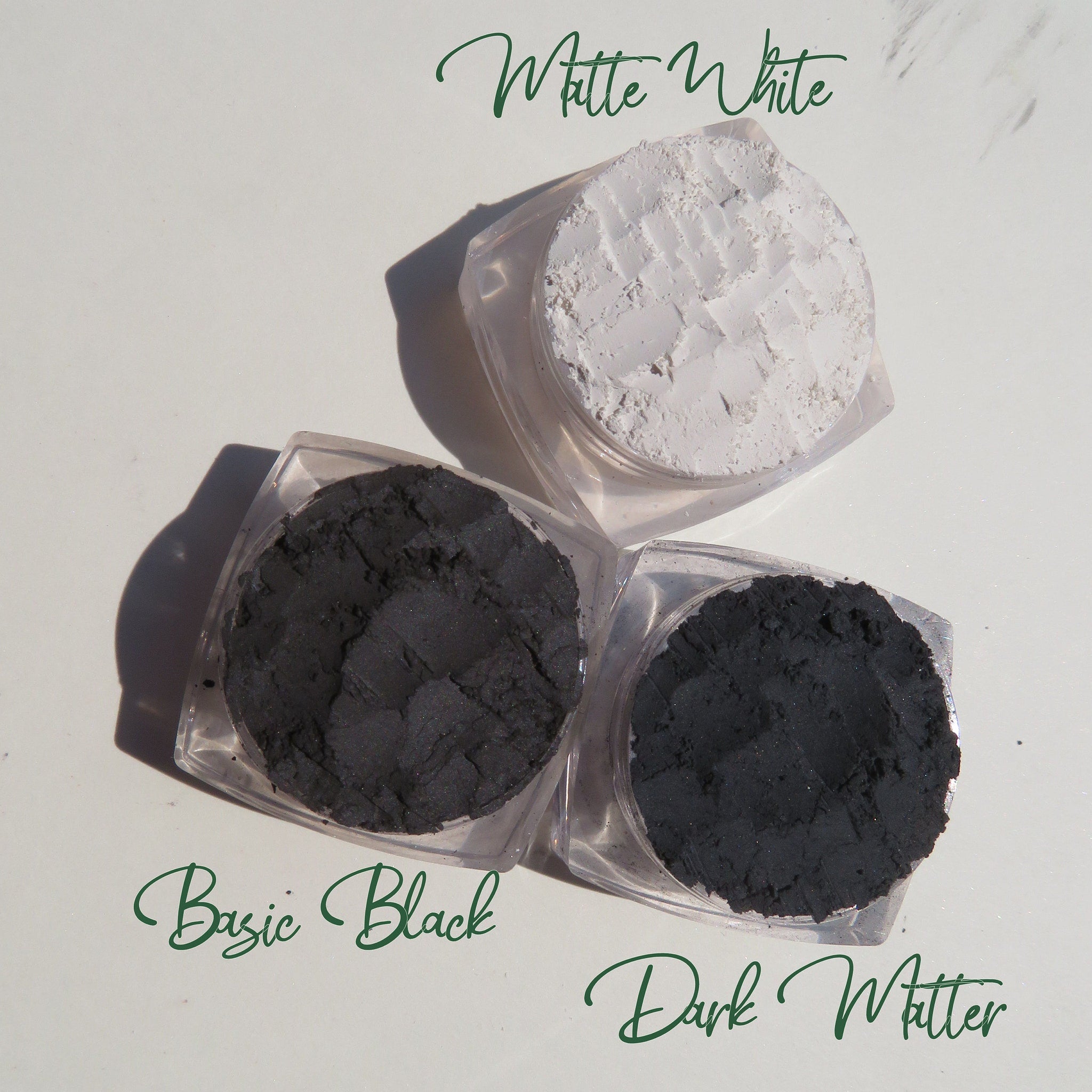 Close-up of matte black and white vegan eyeshadow pans with smooth mineral texture in compact palette