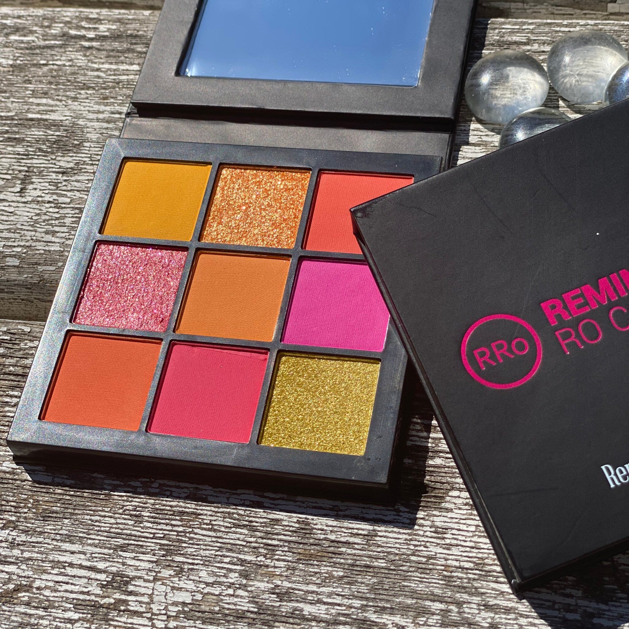Eyeshadow palette with multiple bright colors and RRO branding on black case