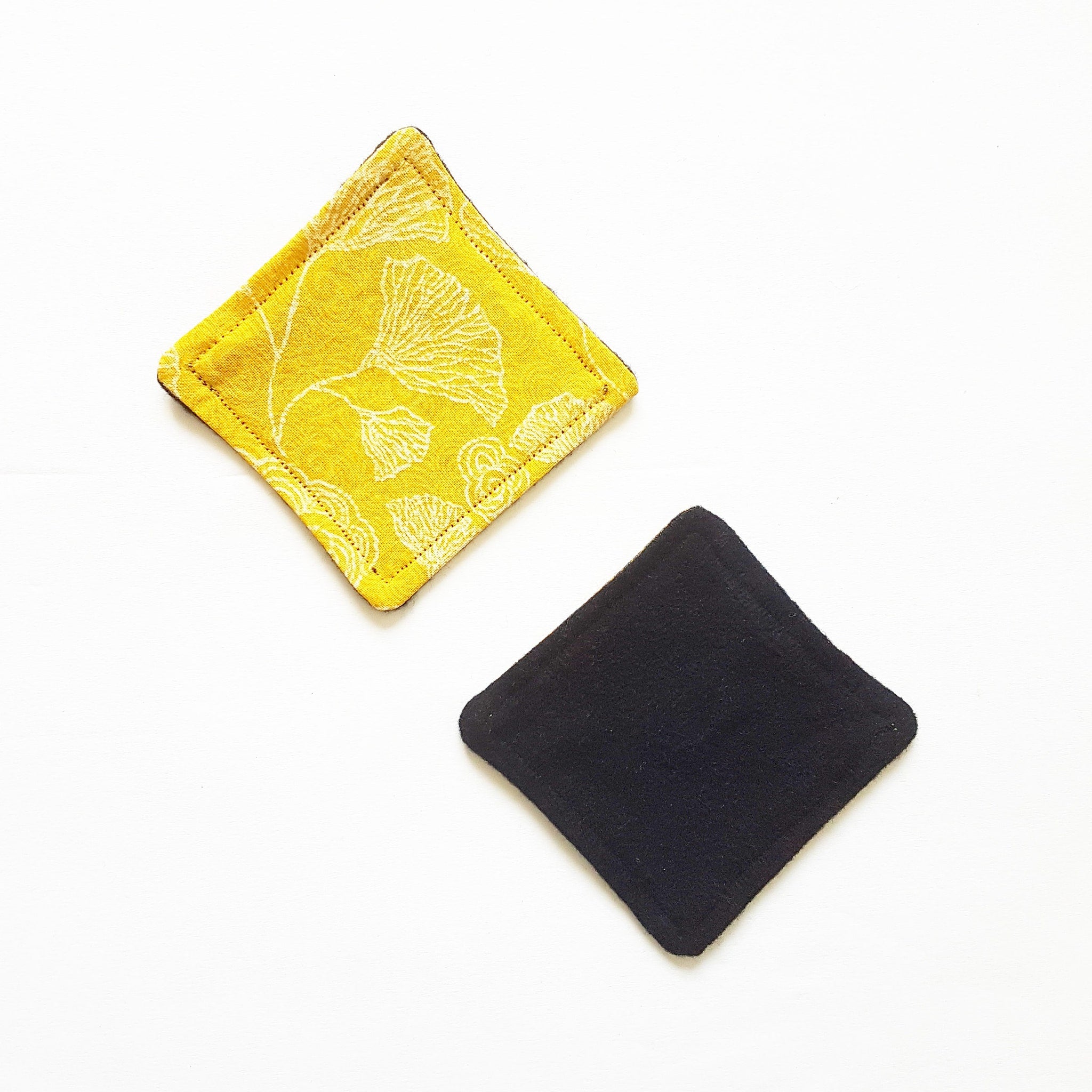 Square fabric coasters, yellow floral pattern, black solid, stitched edge detail