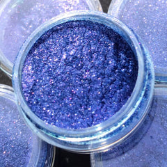 Close-up of shimmery eyeshadow pigment showing vibrant color payoff and fine glitter particles