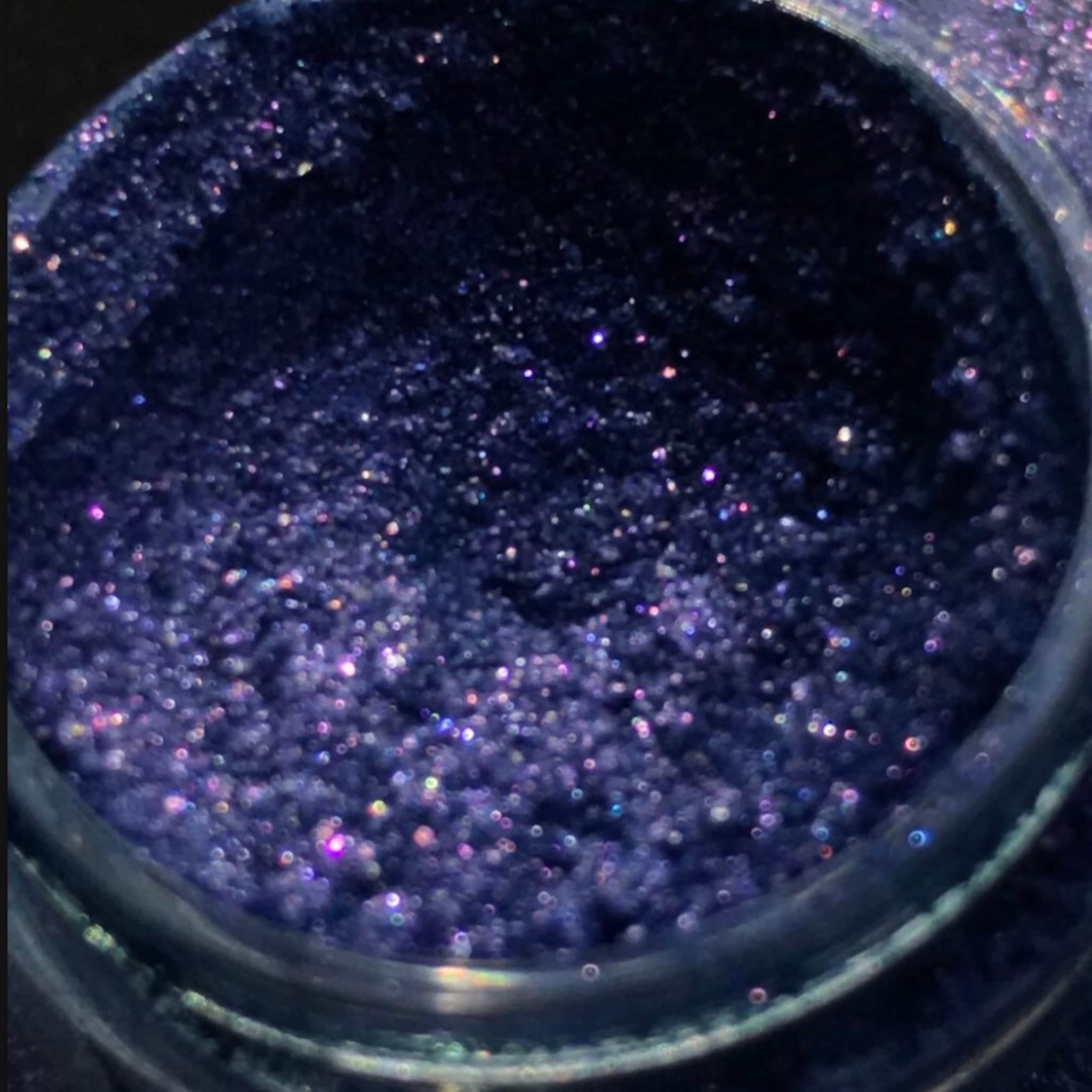 Open compact showing shimmery single-color eyeshadow pigment with reflective surface in multi-shade options