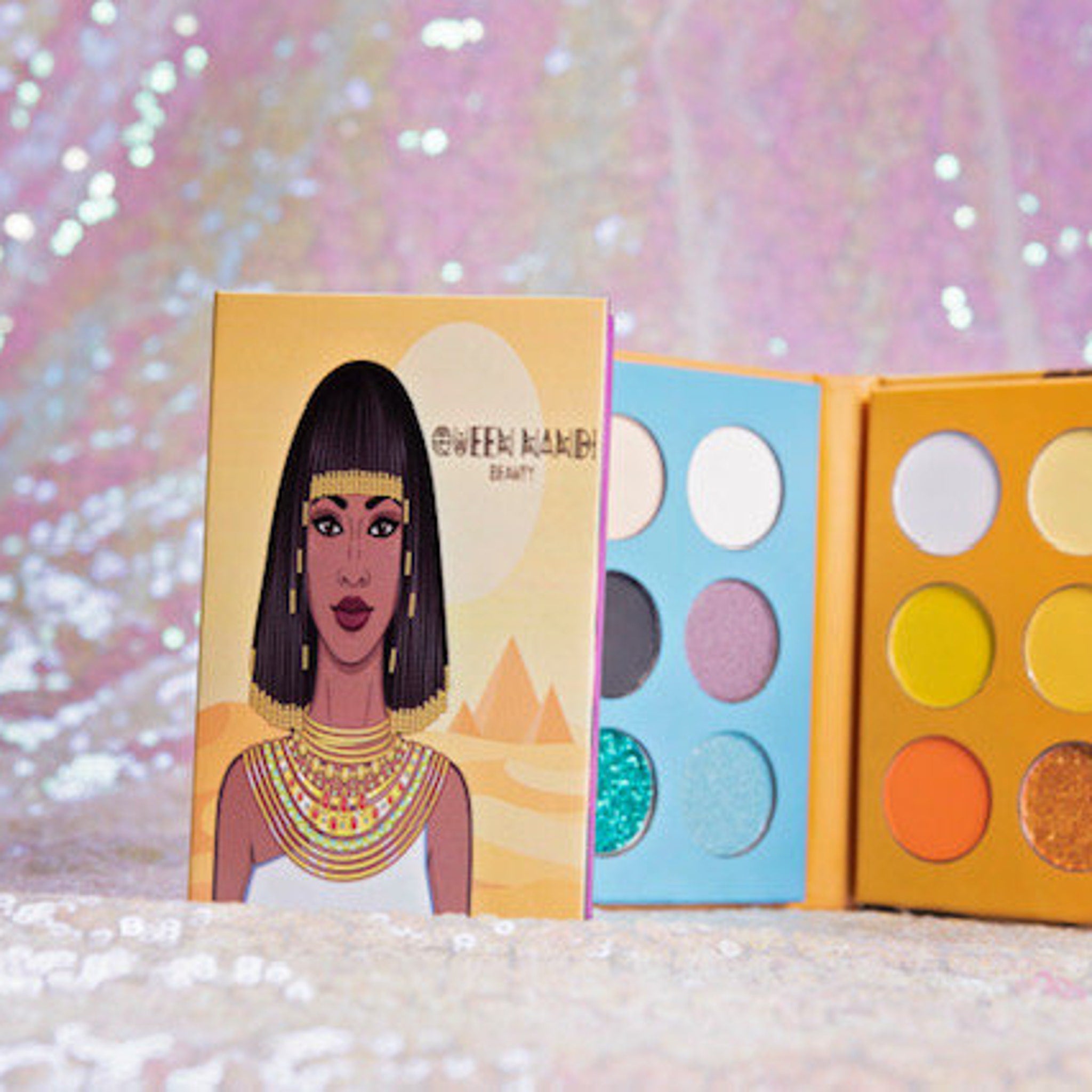 Close-up of 18 vibrant eye shadow pans in matte and shimmer finishes inside sleek black palette