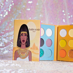 Close-up of 18 vibrant eye shadow pans in matte and shimmer finishes inside sleek black palette