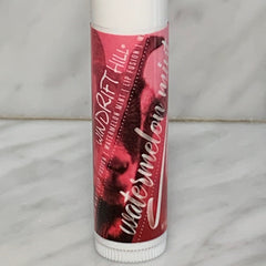 Lip balm tube with pink and white label, Windrift Hill branding, and watermelon text