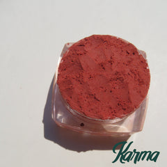 Vegan matte loose mineral eyeshadow in vibrant orange-red shade with smooth powder texture in a small sifter jar