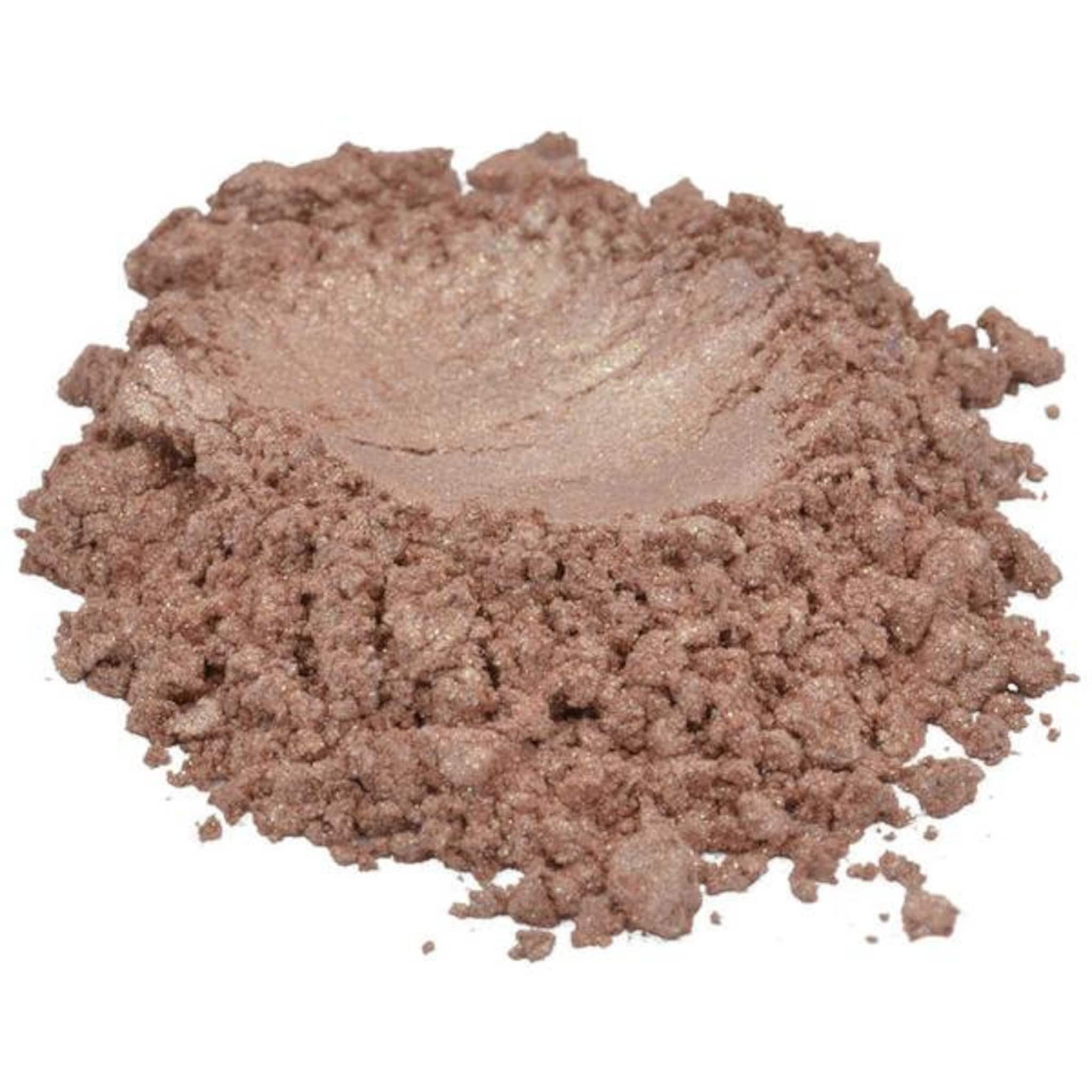 Side view of coral beige mica pigment powder in a clear jar showing shimmer texture and rose pink undertones
