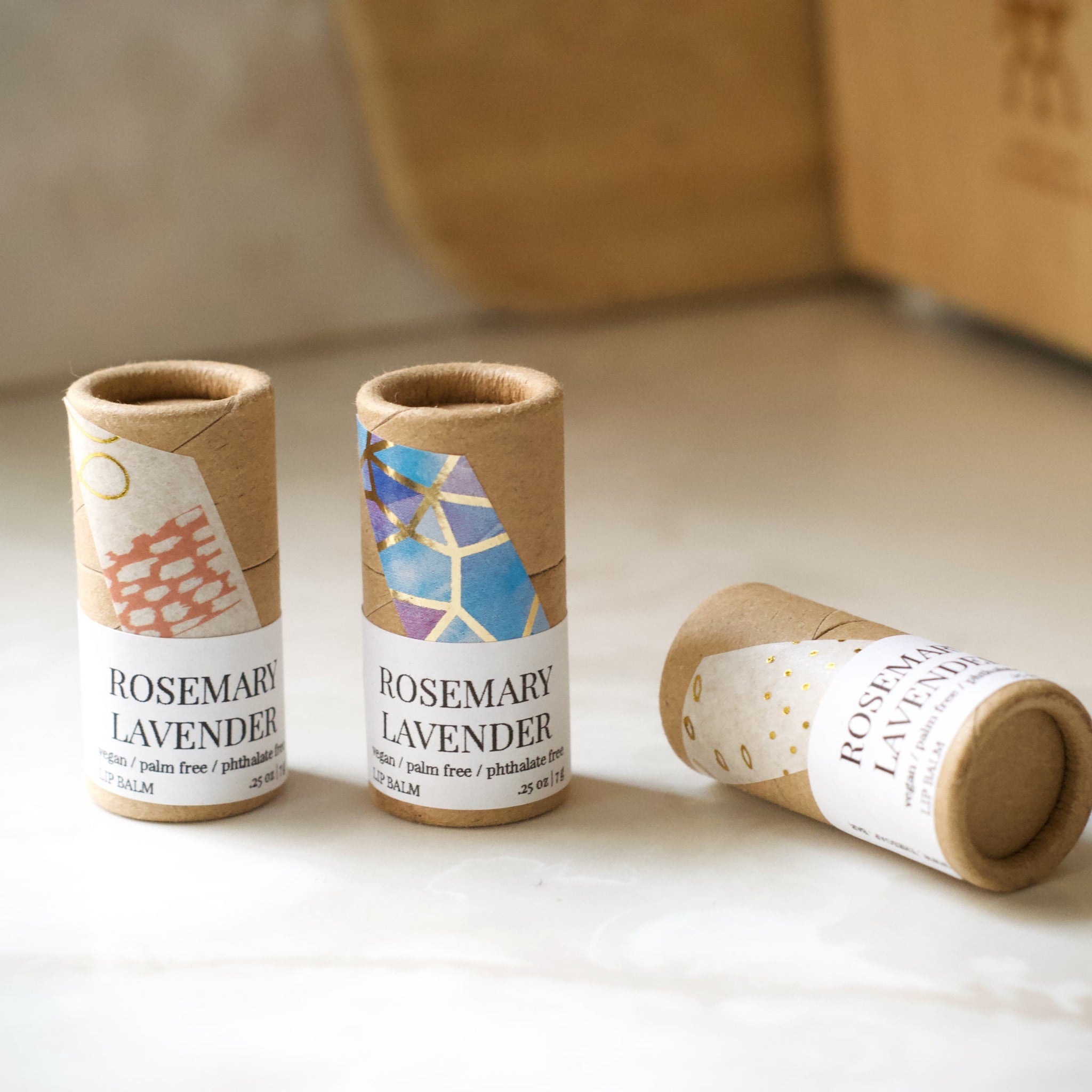 Lip balm tubes with brown cardboard, patterned paper, and "Rosemary Lavender" text label