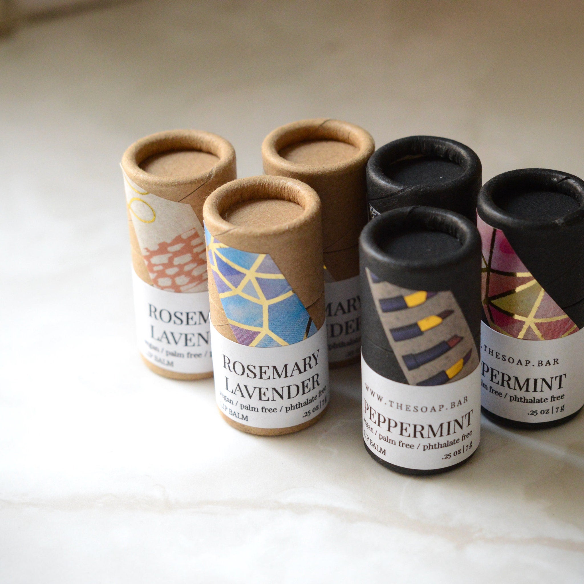 Lip balm tubes in various colors with patterned labels and cardboard material