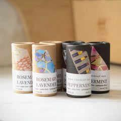Lip balm tubes in various colors with patterned labels, by The Soap.Bar