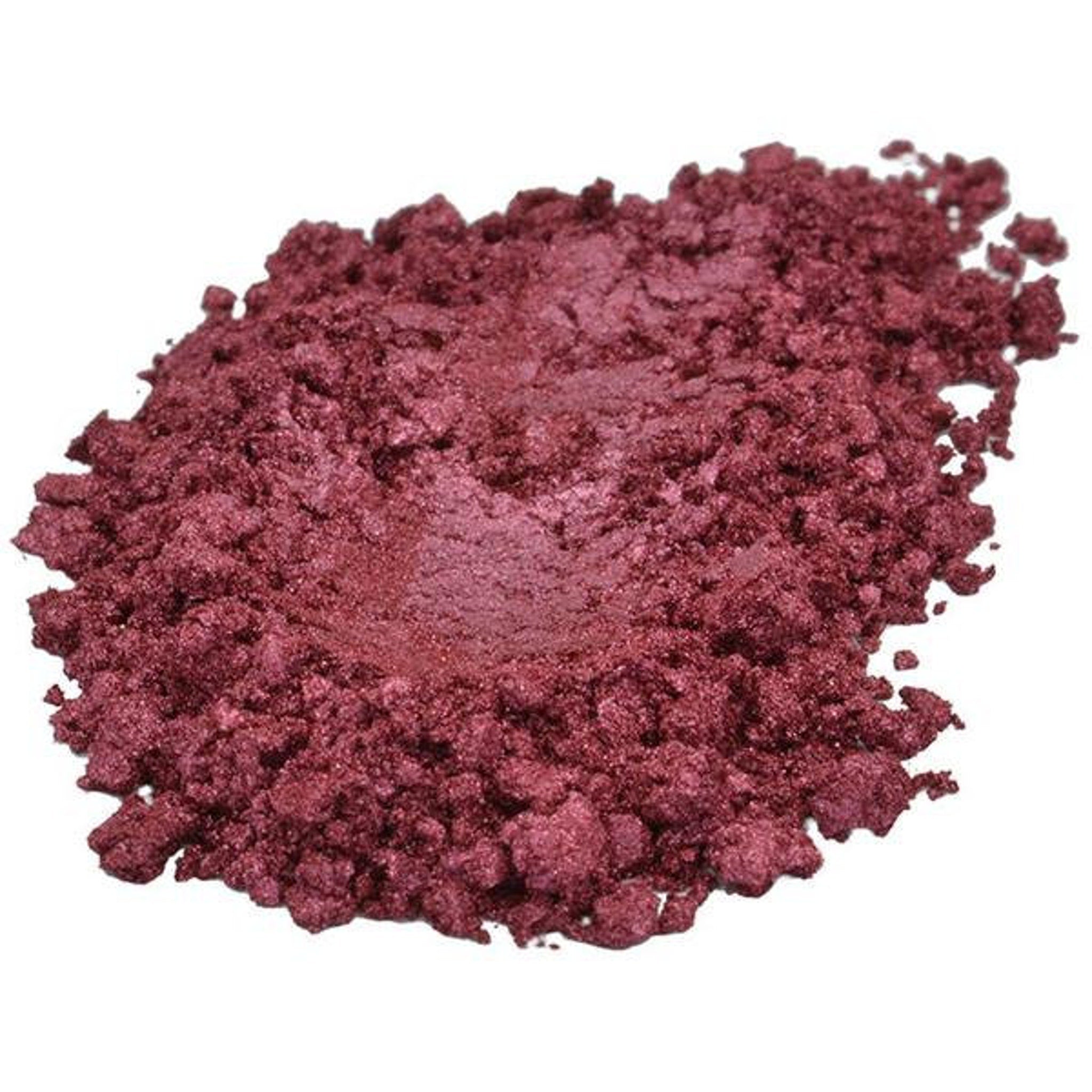Loose powder pigment in burgundy color with a textured, granular appearance.
