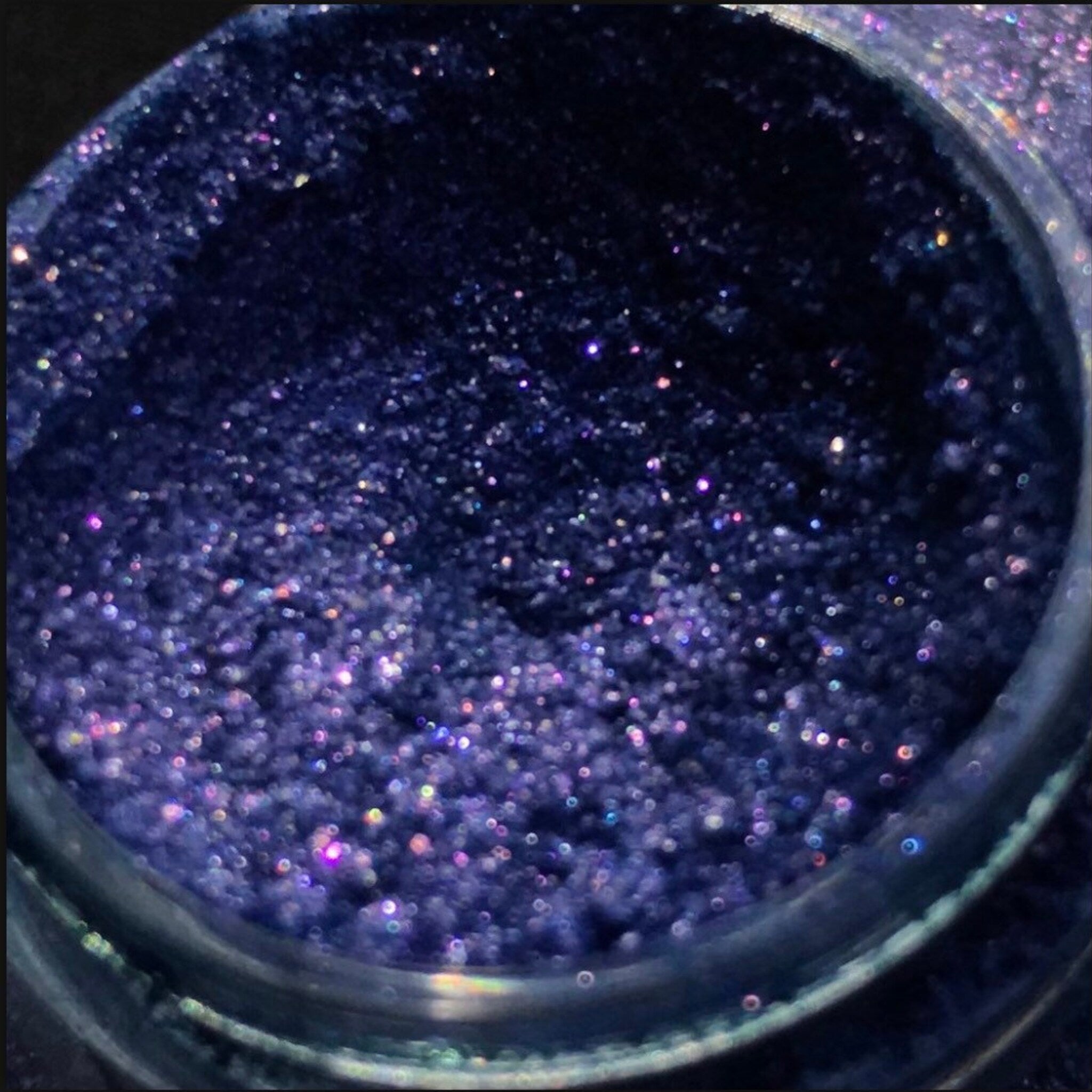 Single shimmery eyeshadow pigment pot in a vibrant shade with metallic finish, showcasing rich color payoff