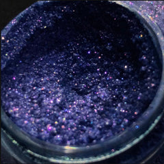 Single shimmery eyeshadow pigment pot in a vibrant shade with metallic finish, showcasing rich color payoff