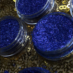 Hand applying shimmery bronze eyeshadow pigment with fingertip for a smooth, blended look on eyelid
