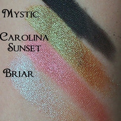 Close-up of coral pink shimmer eyeshadow with golden flecks in compact palette