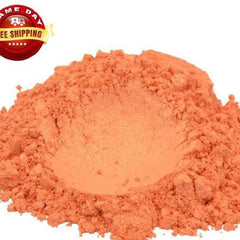 Close-up of vibrant tangerine orange mica pigment powder in a clear jar with gold lid, shimmering under light