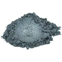 Silver mica pigment powder in storm grey shade spilling from jar onto marble surface
