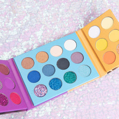 Close-up of makeup brush applying shimmery bronze eyeshadow from palette onto eyelid