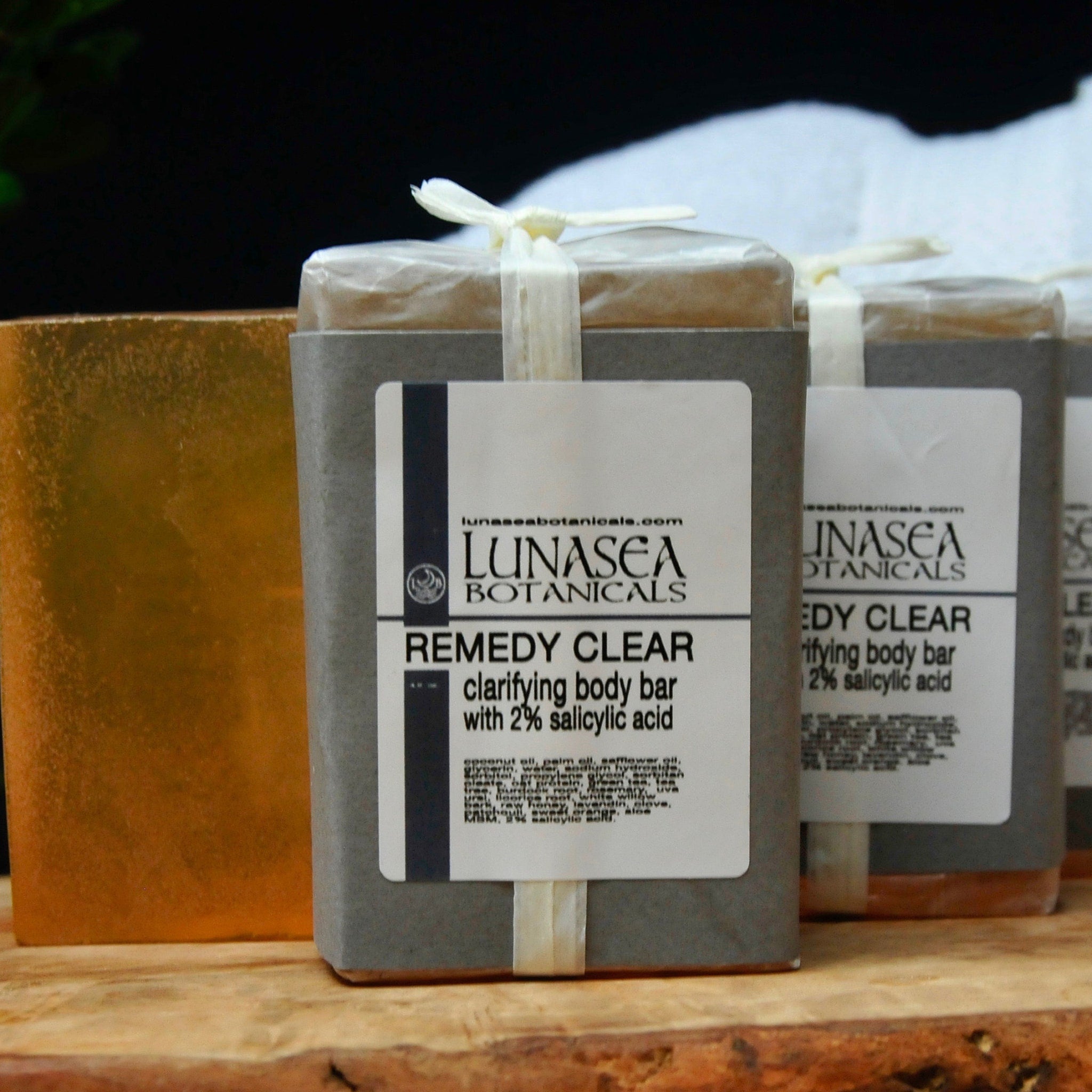 Body bar soap wrapped in gray paper, tied with white ribbon, Lunasea Botanicals label visible