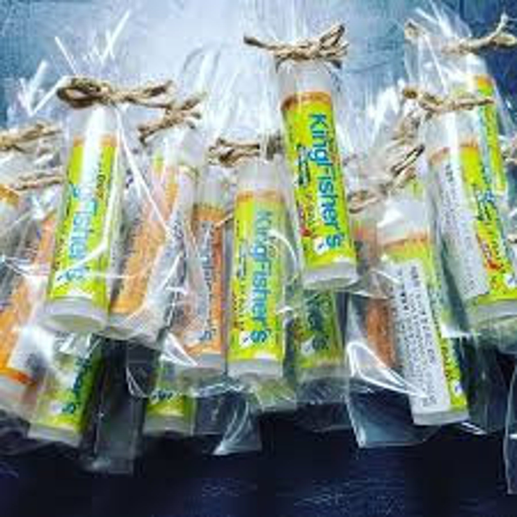 Kingfisher's lip balm tubes, green and orange labels, tied with twine, wrapped in clear plastic.