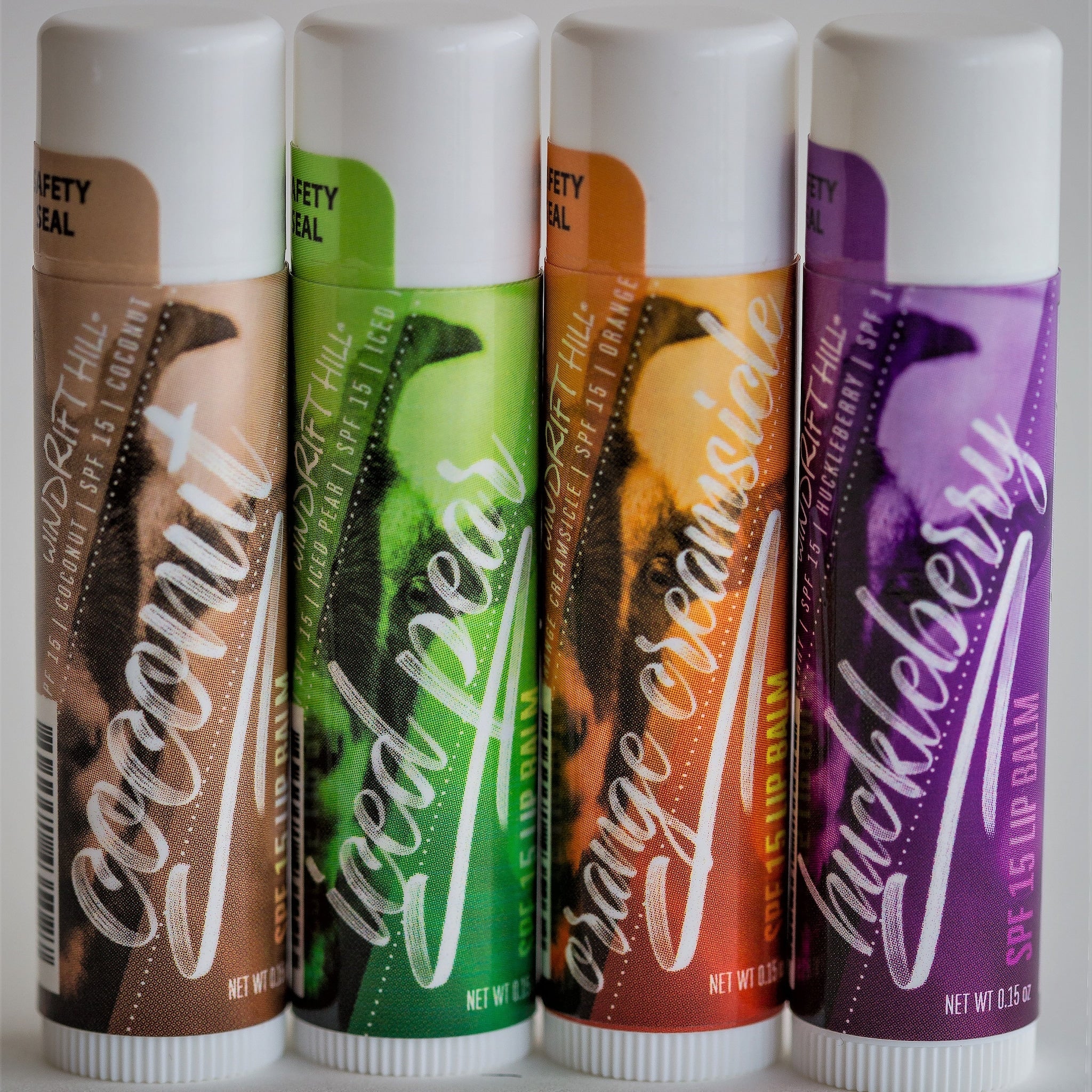 Lip balm tubes with white caps, various colors, and Windrift Hill branding