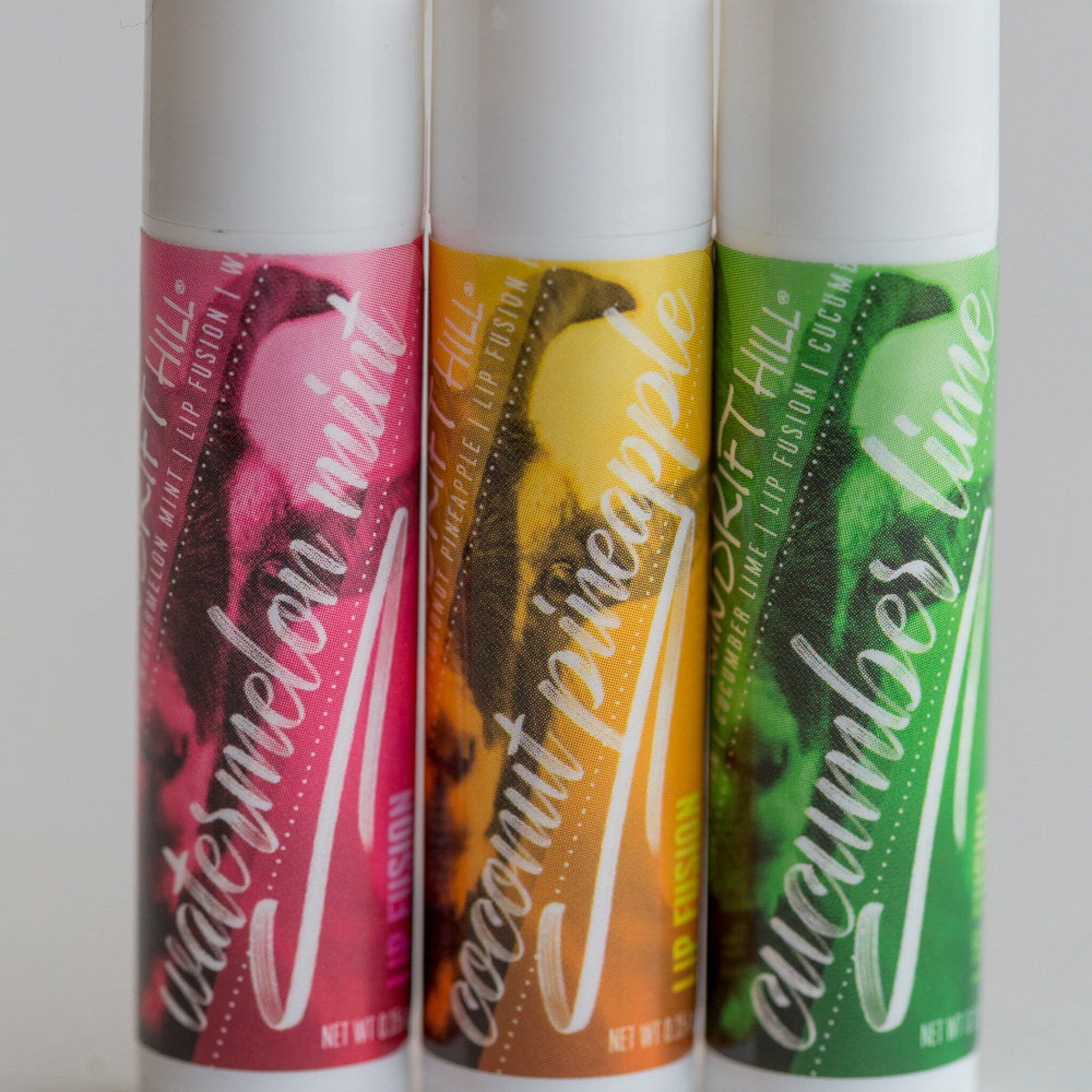 Lip balm tubes with watermelon, coconut, and cucumber labels, Drift Hill brand