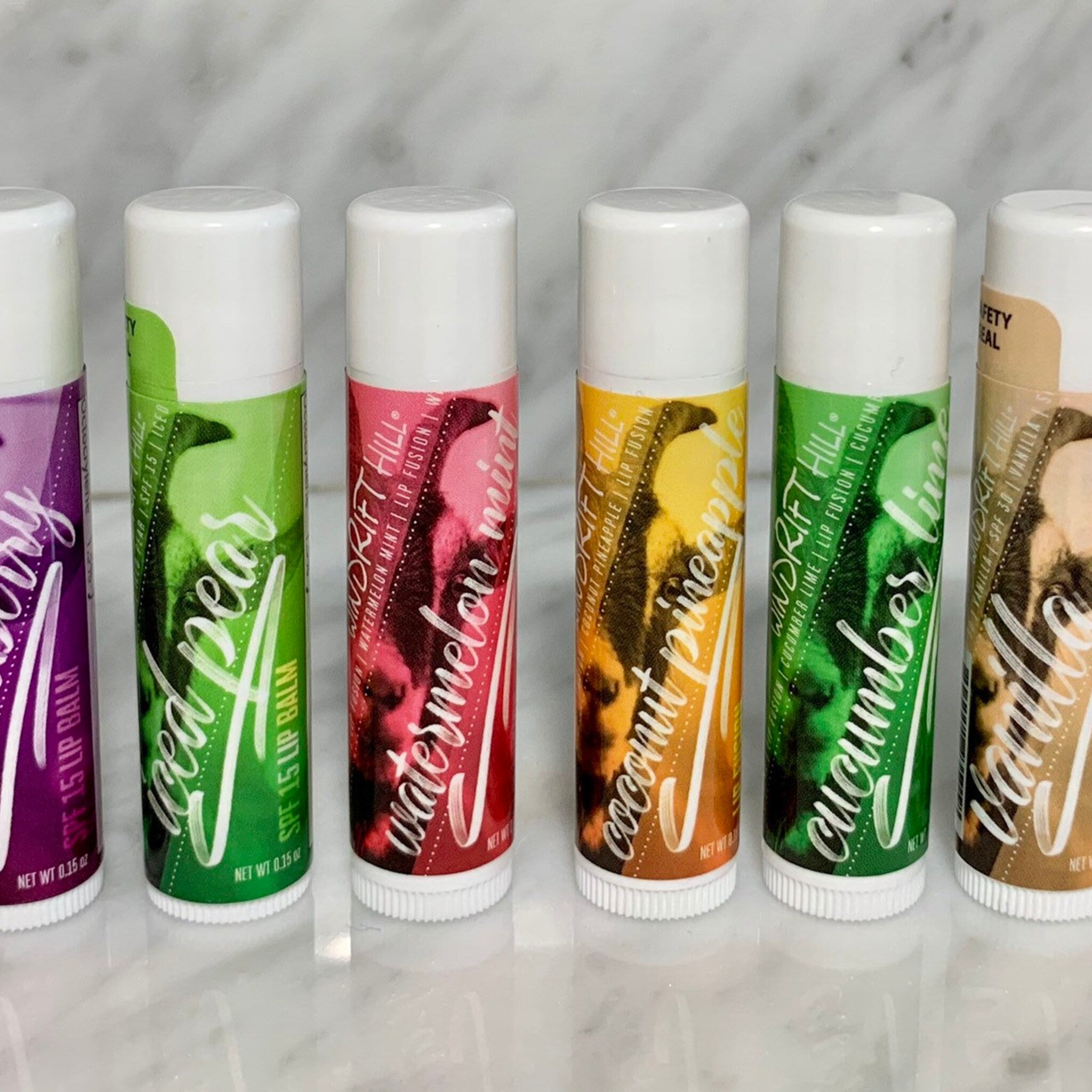 Lip balm tubes with white caps, colorful labels, and Windrift Hill text
