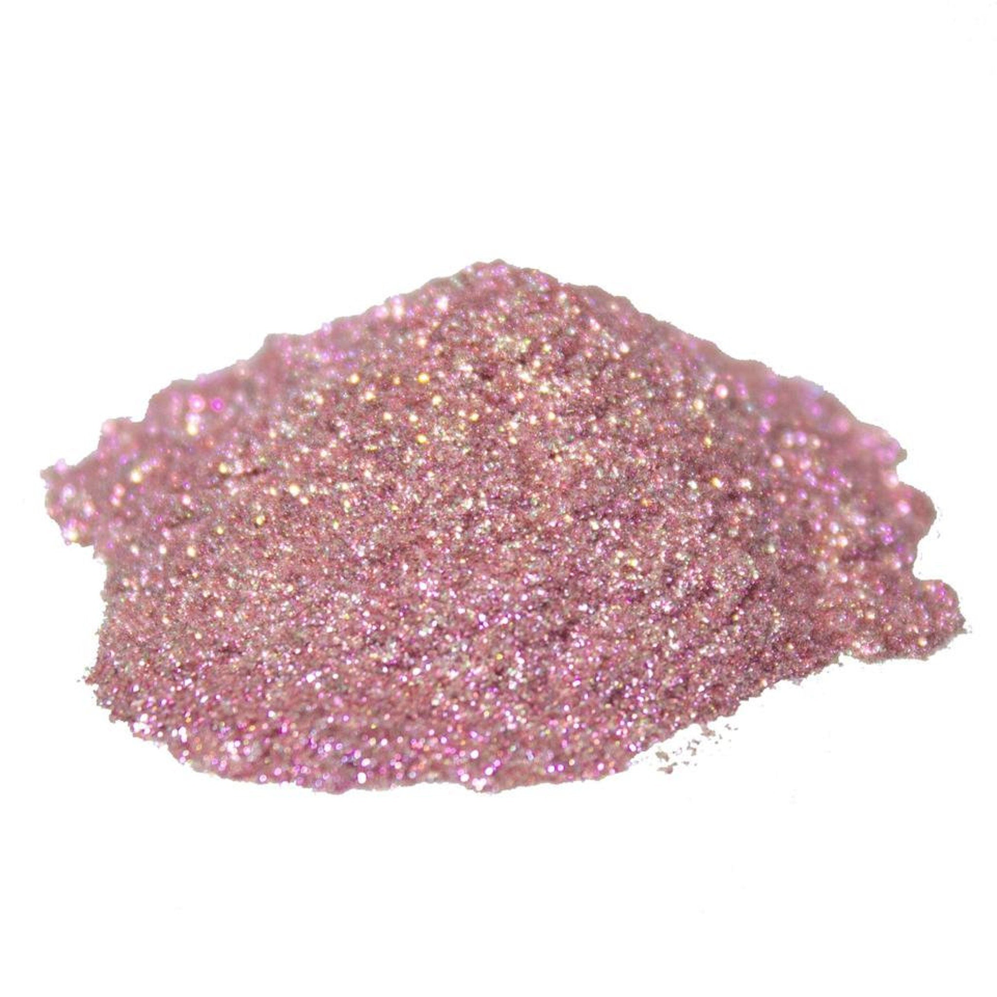 Close-up of sparkling pink glitter pigment powder with starry shimmer in a sleek glass jar