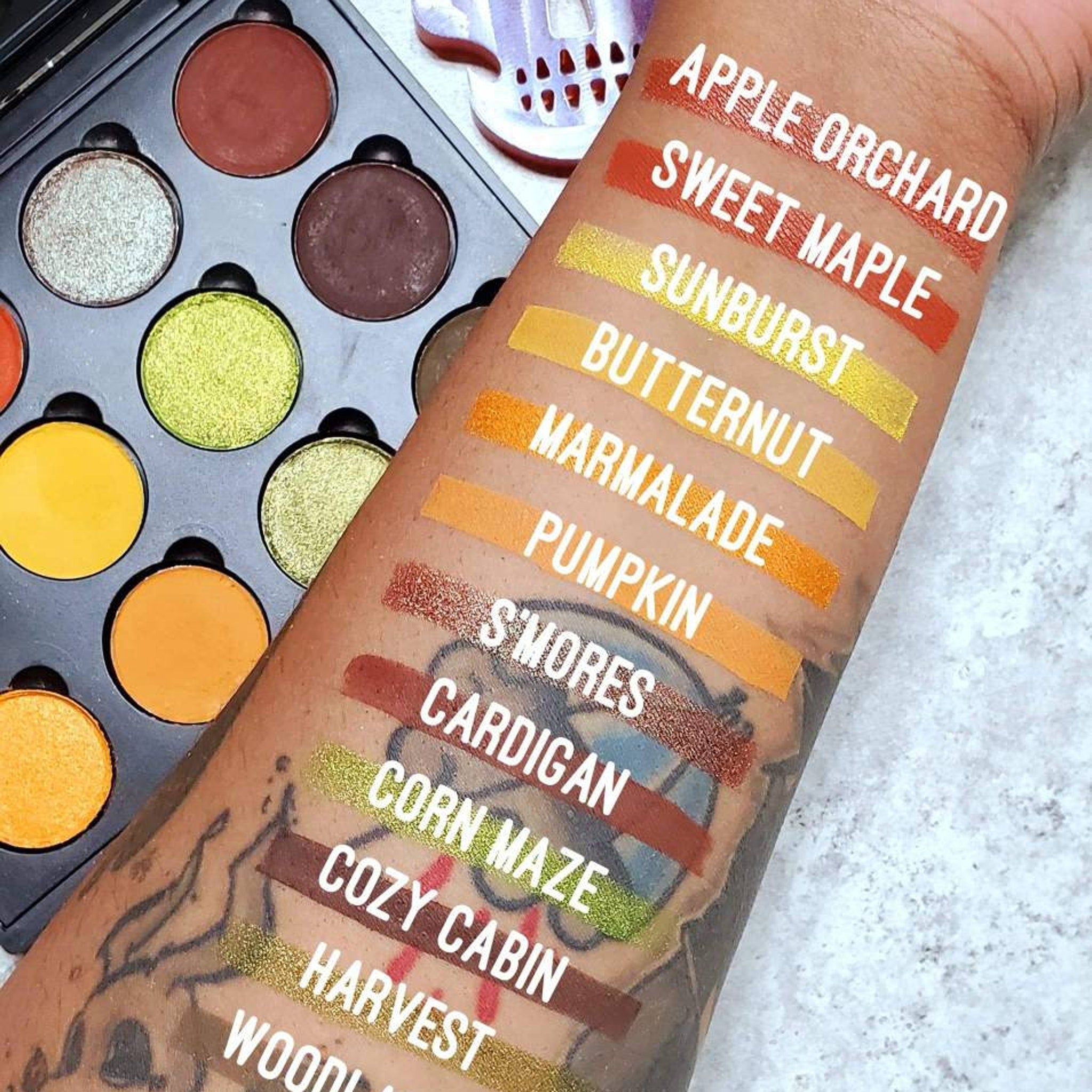 Swatch of Autumn Splendor palette showing vibrant yellow, orange, and red matte shades on light skin tone
