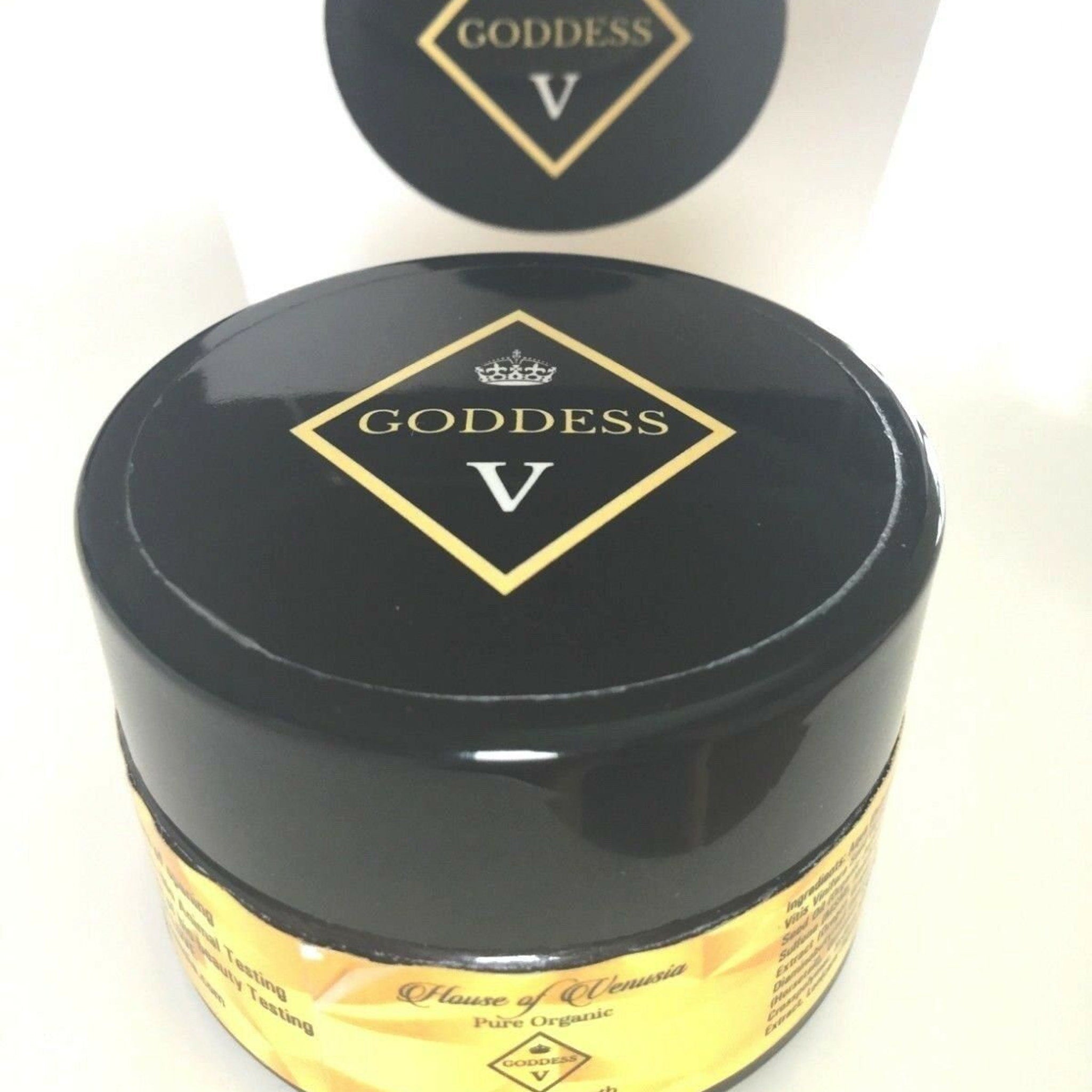 Black jar with gold label and Goddess V text, on white background
