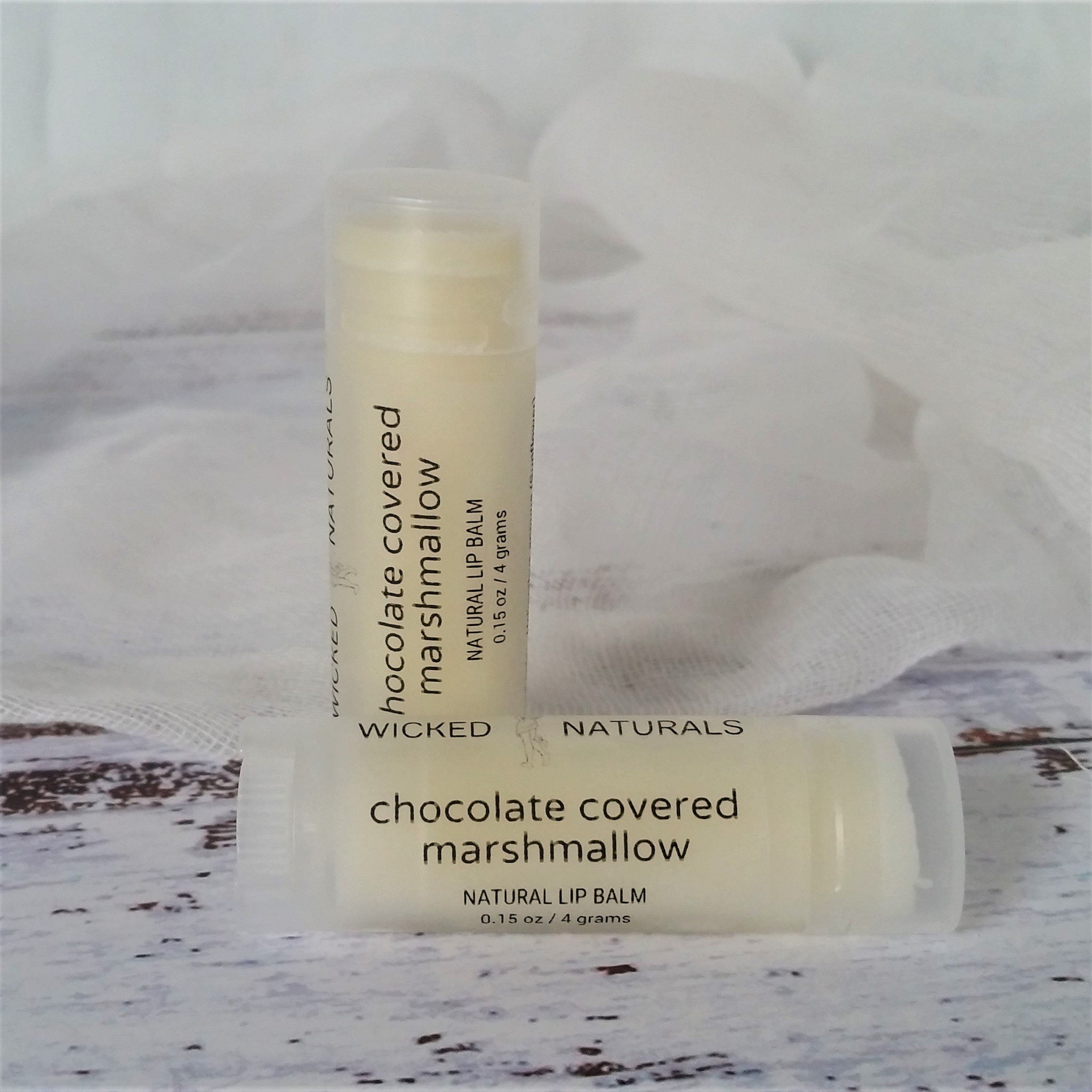 Lip balm tubes with white and black text on a light background, Wicked Naturals brand visible