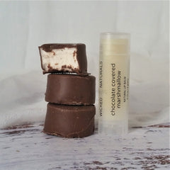 Marshmallow treats with chocolate coating stacked, and lip balm with text "Wicked Naturals