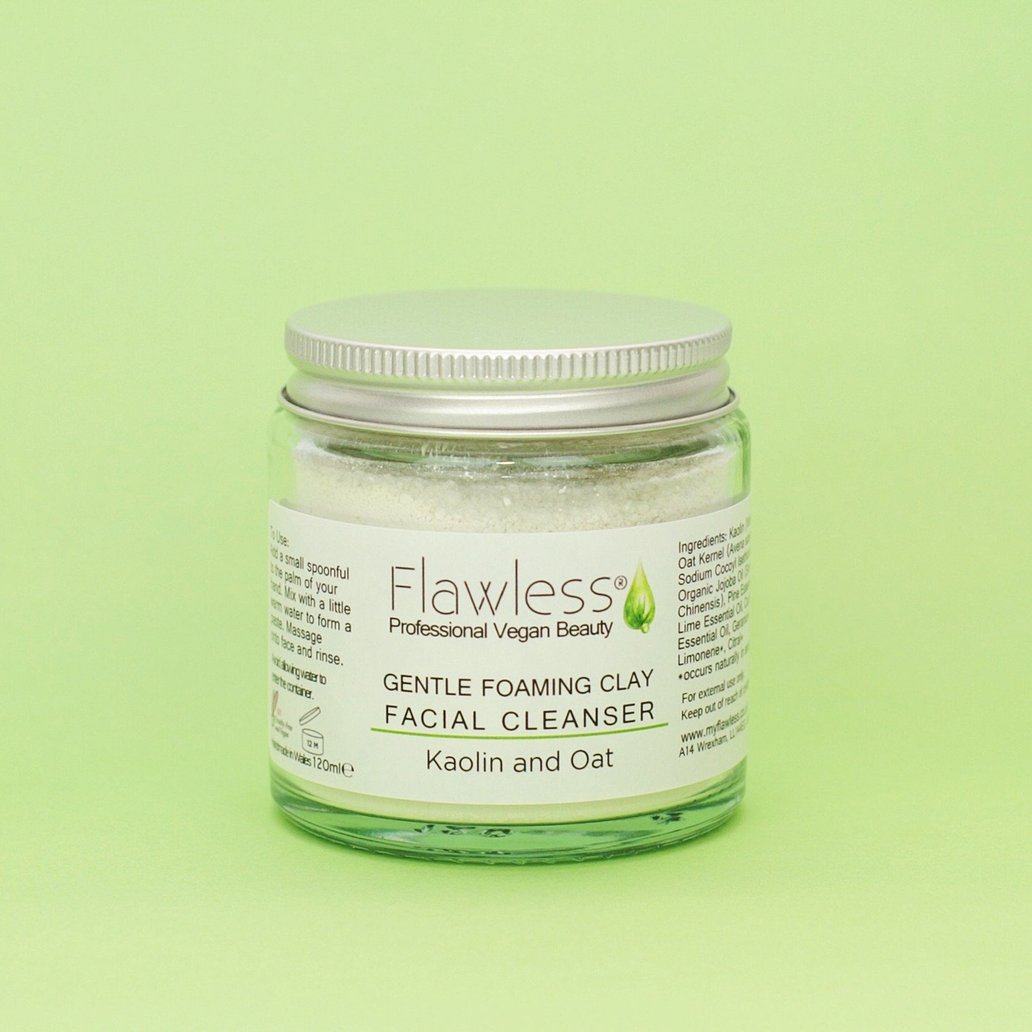 Facial cleanser jar with silver lid, glass body, and Flawless label on green background
