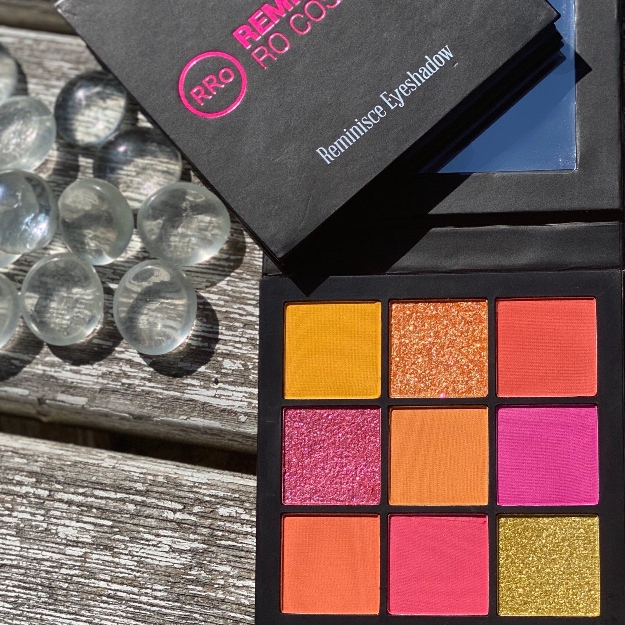 Eyeshadow palette with multiple bright colors, black case, and RRO logo on lid